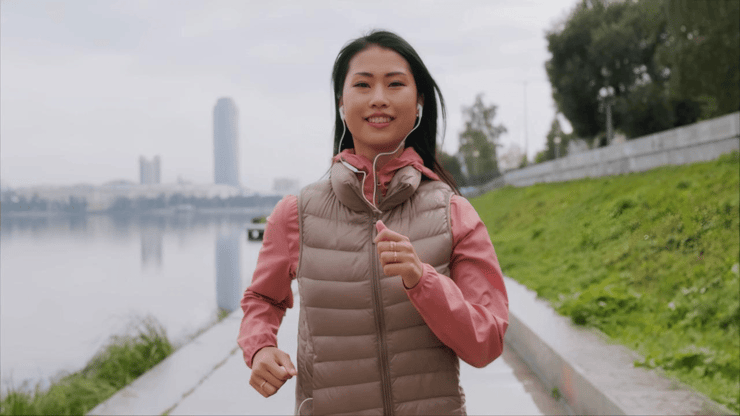 Woman jogging by river after face enhancement